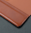 close up of corner of antique tan leather desk pad blotter